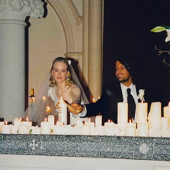 Nicole Kidman and Keith Urban lighting candles together, highlighting reactions to their split in a candlelit setting.