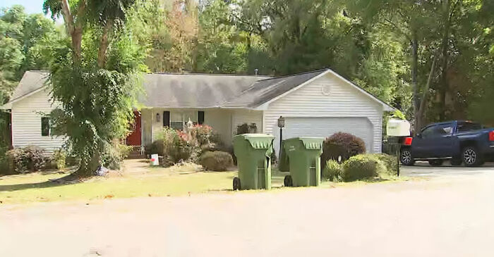 Suburban house with green trash bins and a pickup truck, location linked to pastor's son accused of disturbing acts captive case.