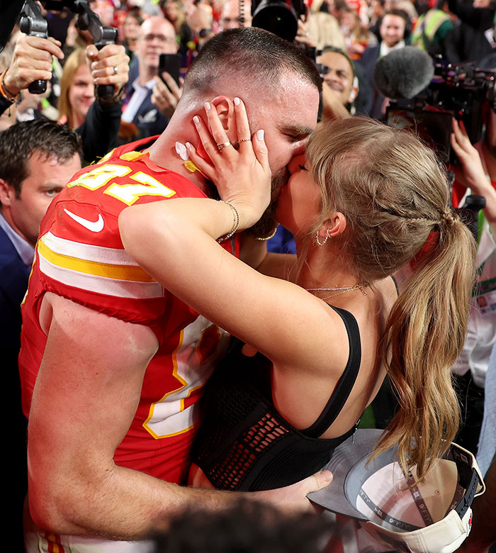Travis Kelce and Taylor Swift kissing at a crowded event, highlighting Travis Kelce&rsquo;s answer about Taylor Swift.