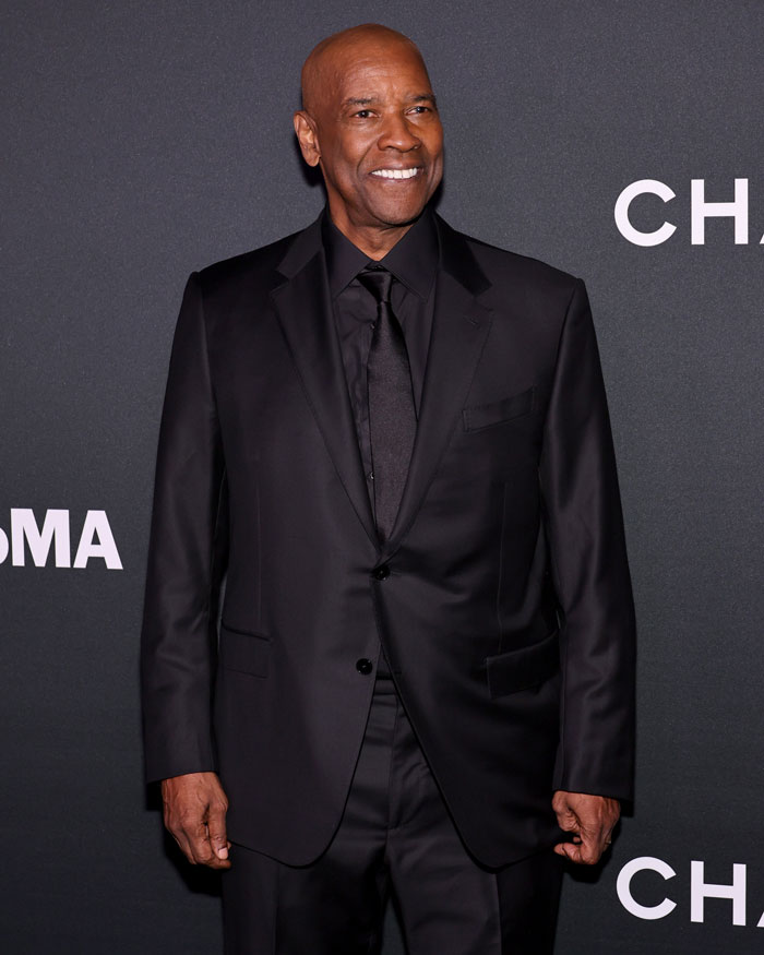Denzel Washington in a black suit smiling at an event, related to the correct way to pronounce his name discussion. Denzel Washington in a black suit smiling at an event, related to the correct way to pronounce his name discussion.