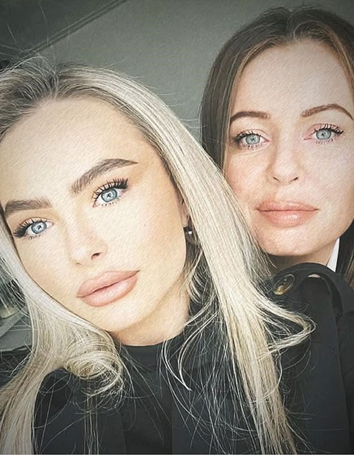 Two women with light eyes and styled hair posing closely together in a well-lit indoor setting for a photo. Two women with light eyes and styled hair posing closely together in a well-lit indoor setting for a photo.