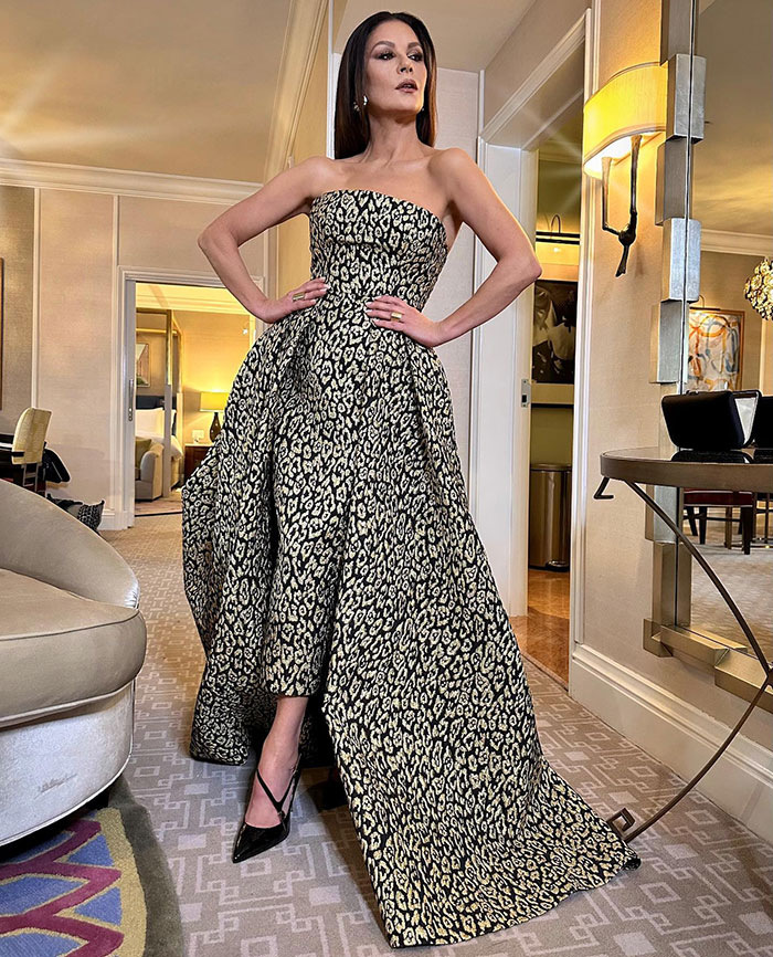 Catherine Zeta-Jones posing in a patterned strapless gown indoors amid controversy over creepy comment about 12-year-old fan.