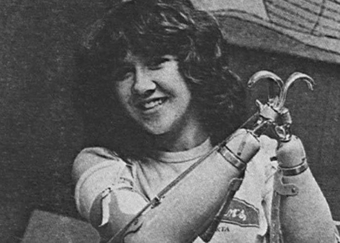 Young woman smiling while showing mechanical prosthetic arms, representing terrifying true stories of human resilience.