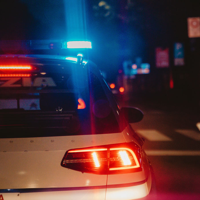 Police car with flashing lights at night on a city street, illustrating professors who left an impression with hilarious reviews.