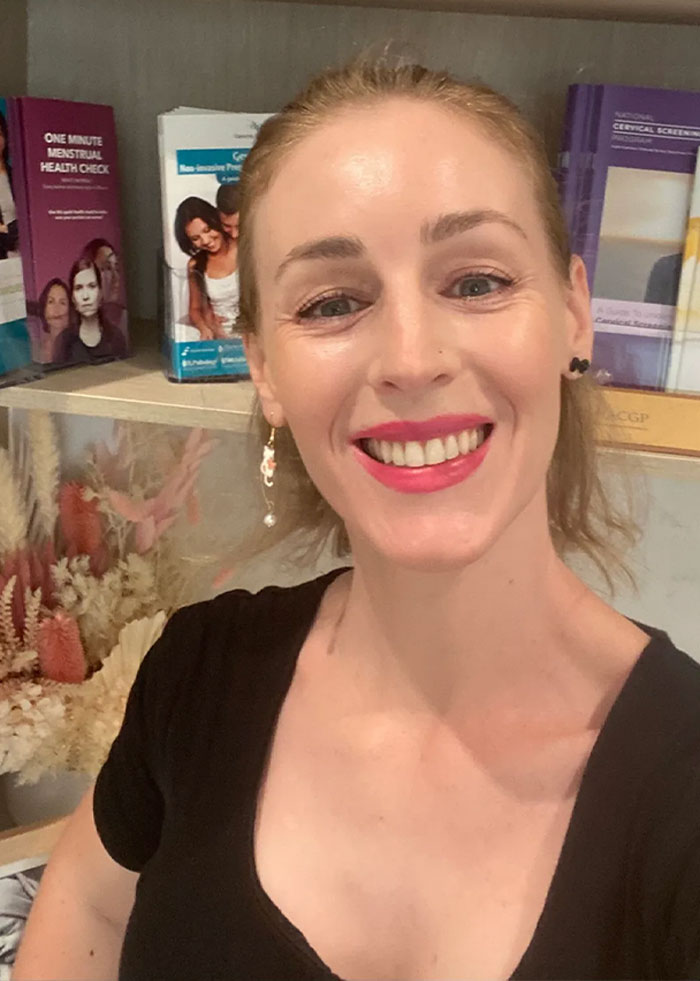 Smiling doctor in a black shirt raising awareness about breastfeeding stigma and health risks related to pumping breast milk at airport.