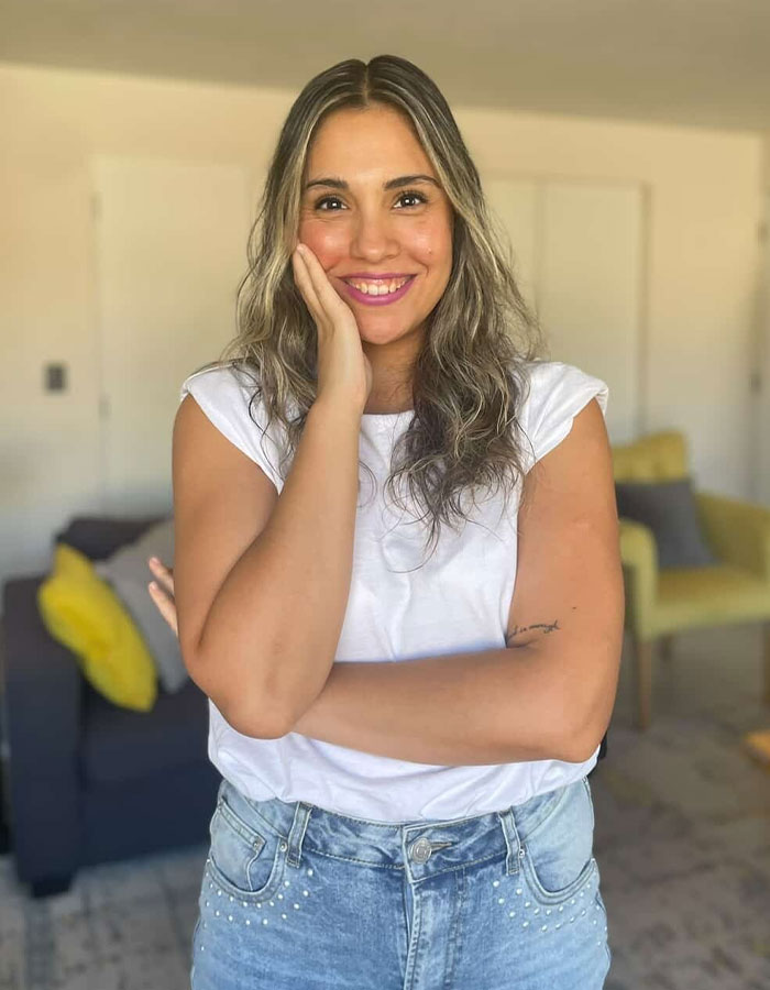 Woman smiling confidently indoors, representing viral food engineer exposing supermarket products that trick shoppers.
