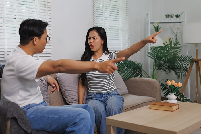 Man and wife having heated argument at home, woman upset as husband gives ultimatum over plastic surgery decision.