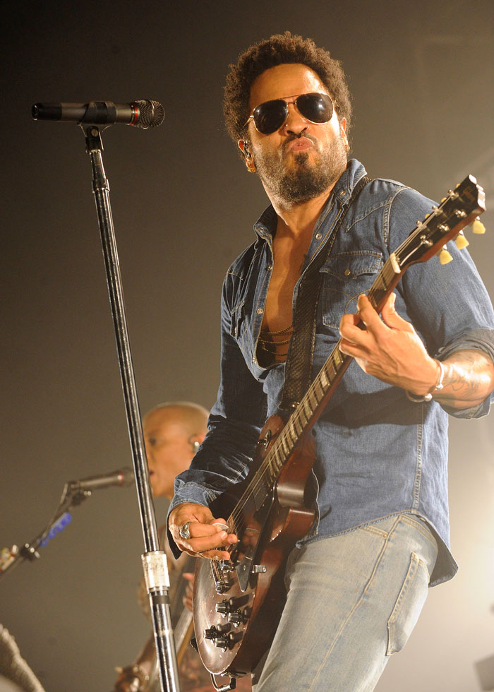 Musician playing electric guitar on stage with microphone, capturing a moment of live performance oopsies.