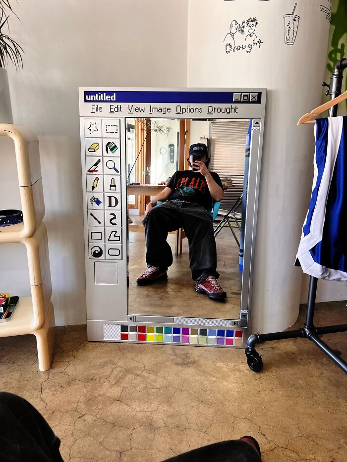 Mirror designed like a vintage computer paint program reflecting a person sitting, showcasing one of the weirdest purchases.