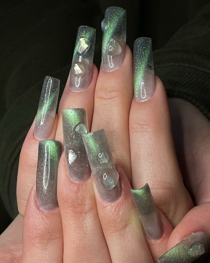 Long acrylic nails with green shimmer and 3D water droplet nail designs showcasing bold nail designs.