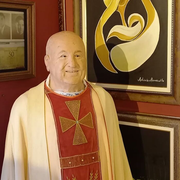 Wax sculpture of a famous figure dressed in religious robes, showcasing creepy and hilarious details by the artist.