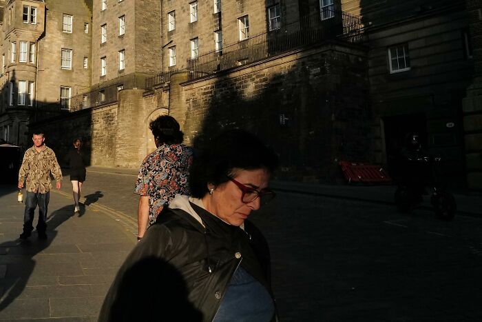 Street photo of people walking on a sunlit city street capturing the funny side of life in an urban setting.