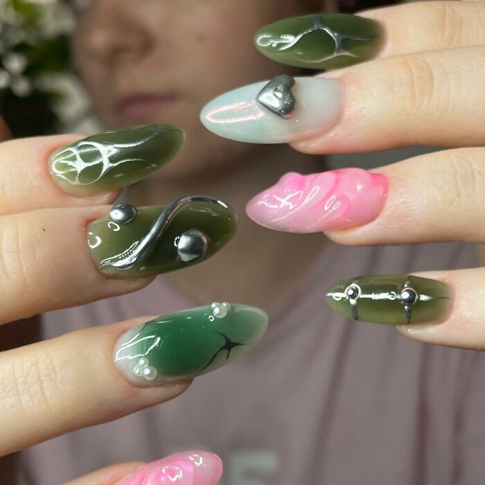 Unique nail designs featuring green, pink, and mixed colors with 3D metallic and pearl embellishments on long nails.