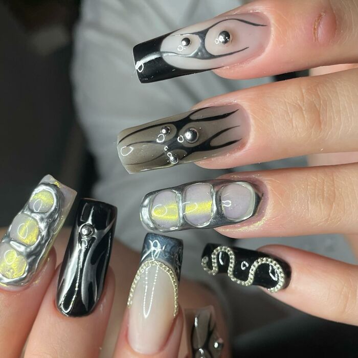 Unique black and silver 3D nail designs breaking all the rules with bold patterns and textured embellishments on long nails.