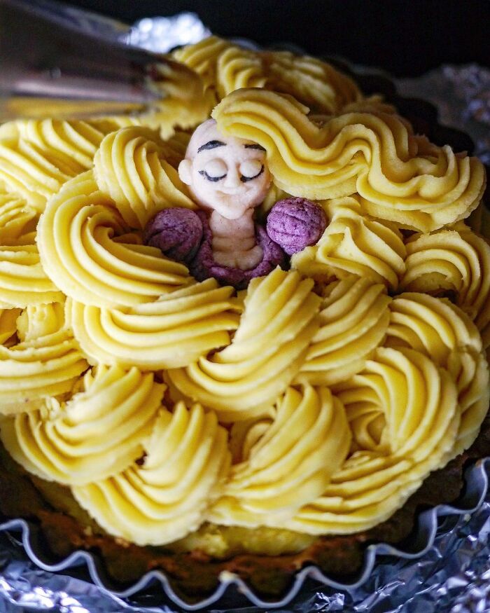 Creative meal by Japanese mom featuring a detailed edible figure with vibrant yellow and purple frosting on a decorative plate.