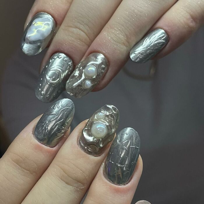 Metallic textured nail designs with 3D pearl accents showcasing unique creative nail art trends