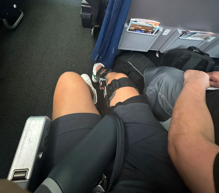 Passenger’s view of cramped airplane seatmate situation during nightmare flight caused by seatmate soiling himself before takeoff. Passenger’s view of cramped airplane seatmate situation during nightmare flight caused by seatmate soiling himself before takeoff.