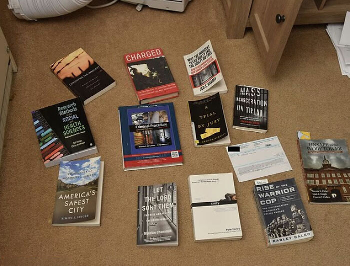 Books about criminal procedure and Idaho crimes laid out on carpet in relation to Bryan Kohberger's mom discussing Idaho crimes before arrest.