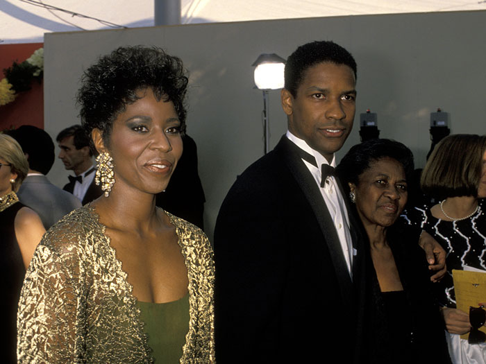 Denzel Washington with two women at an event, spotlighting the correct way to pronounce his name for years. Denzel Washington with two women at an event, spotlighting the correct way to pronounce his name for years.