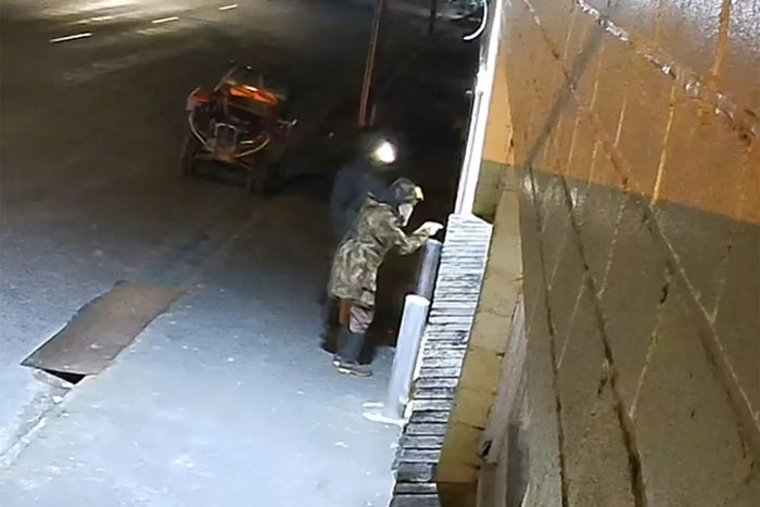 Two individuals in winter clothing standing near a building at night, related to fugitive dad police standoff.