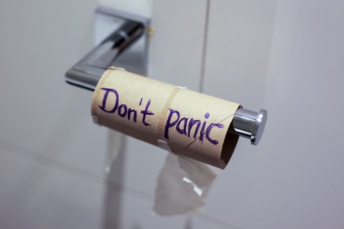 Empty toilet paper roll with a handwritten note saying don't panic, symbolizing chaotic moments faced by food delivery drivers.