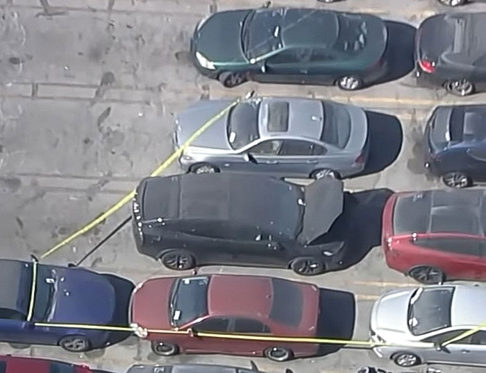 Black Tesla parked in a lot surrounded by police tape after decomposing body was found in abandoned vehicle linked to singer.