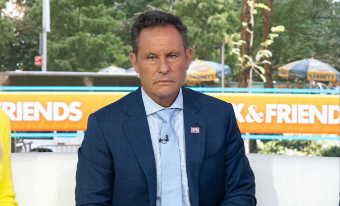 News host in a blue suit discussing Ukrainian refugee attack on live TV, appearing serious during the broadcast. News host in a blue suit discussing Ukrainian refugee attack on live TV, appearing serious during the broadcast.