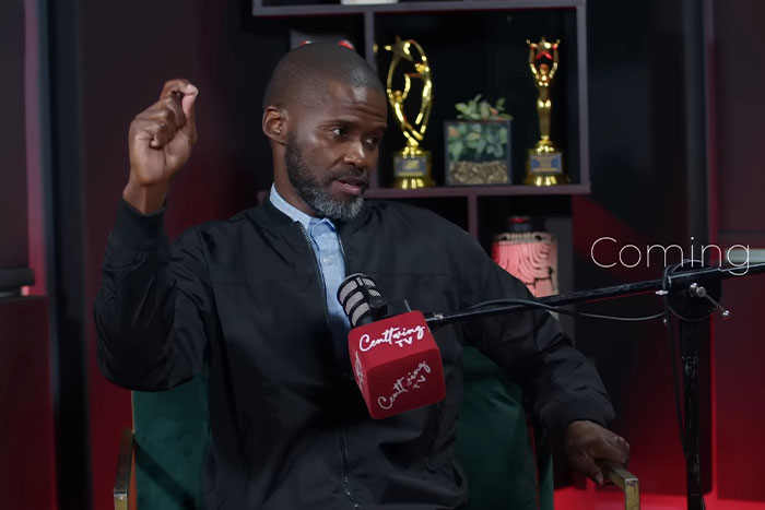 Man speaking into a microphone during a podcast recording about RaptureTok and end of the world predictions in September.