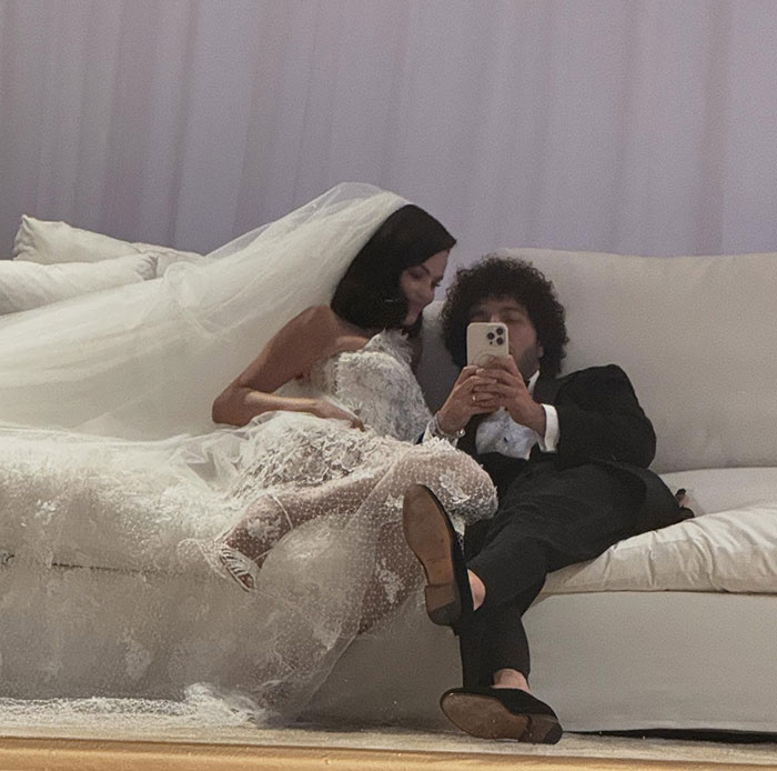 Bride and groom relaxing on couch during wedding while Taylor Swift steals the spotlight with a memorable speech.