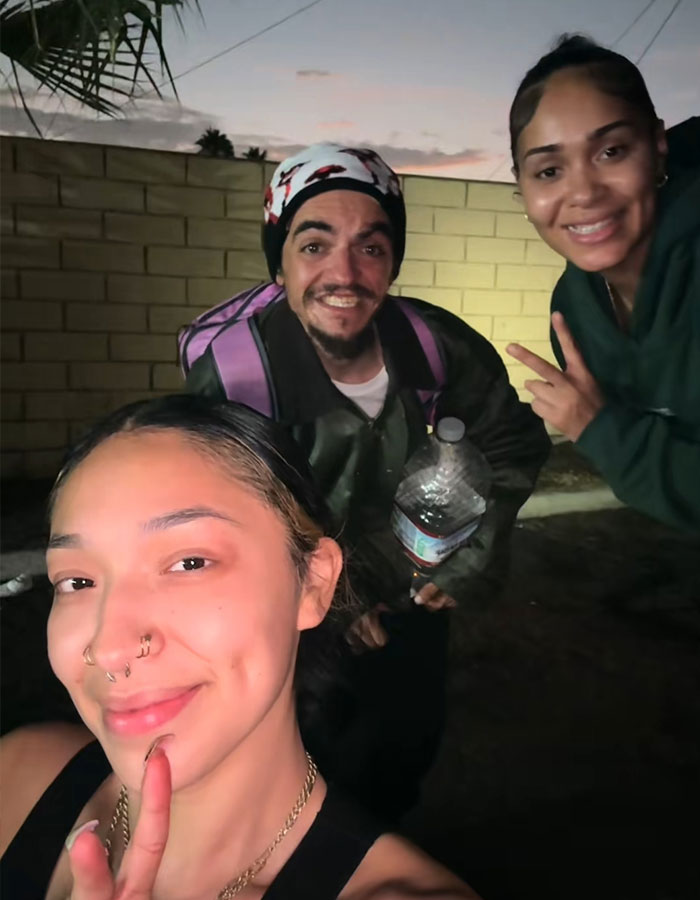 Three smiling people at dusk celebrating a fundraiser for homeless Nickelodeon actor with a street-side makeover.