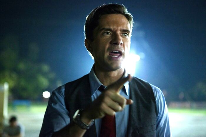 Man pointing and speaking passionately at night outdoors, capturing the moment of meeting an idol experience.