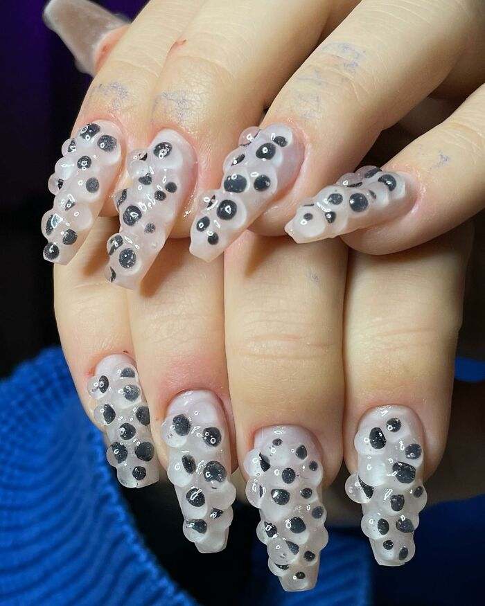 Unique 3D textured nail designs with black spots on translucent nails, showcasing bold and creative nail designs.