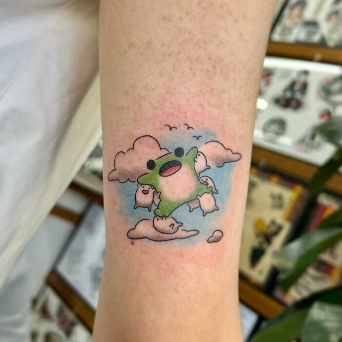 Colorful adorable frog and animal tattoo on arm with clouds and small birds, by Korean artist Buoy.