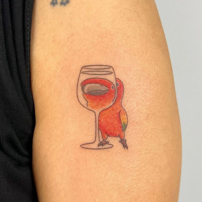 Minimalist animal tattoo of a colorful bird and wine glass by Korean artist Buoy, showcasing adorable animal tattoo designs.