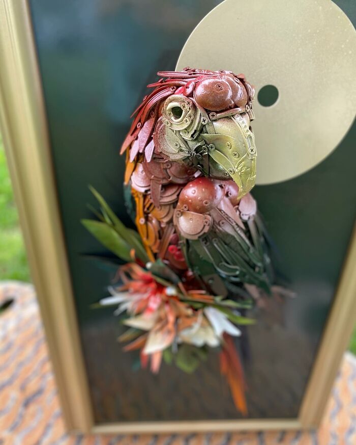 Parrot sculpture made from recycled metal trash, showcasing stunning animal sculpture art with detailed colorful parts.