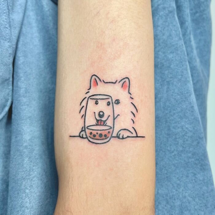 Minimalist animal tattoo of a dog peeking over a table with a drink, created by Korean artist Buoy.