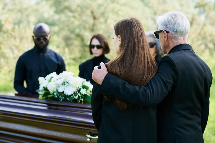 Mourners at a funeral, reflecting the moment they realized they had fallen out of love during a somber gathering.