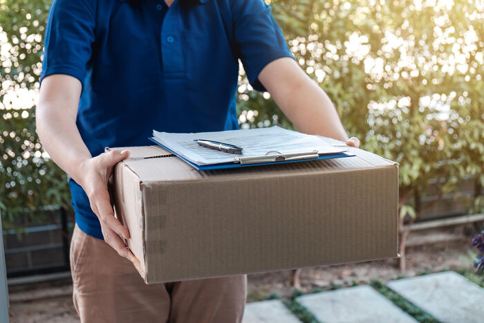 Person in a blue shirt holding a cardboard box with clipboard and pen, illustrating mind-boggling conversations with adults concept.