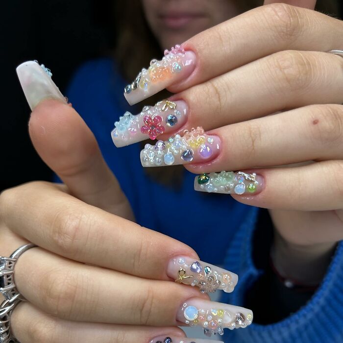 Long acrylic nails with colorful 3D nail designs and gems, showcasing creative and unique nail art styles.