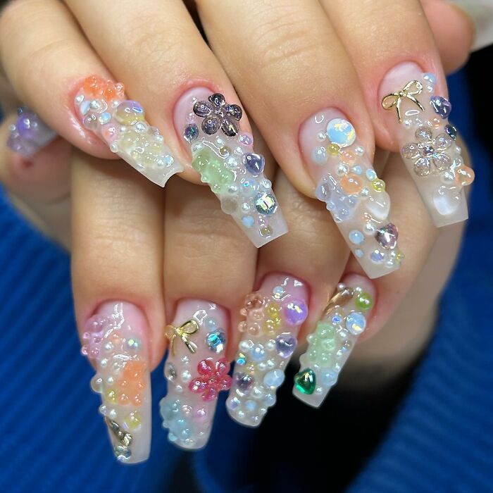 Long acrylic nails with colorful 3D nail designs and gems, showcasing creative and unique nail art styles.