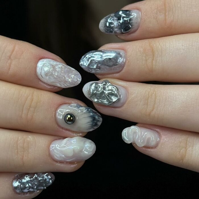 Unique silver and white nail designs with textured, glossy 3D effects showcasing bold and creative nail art styles.