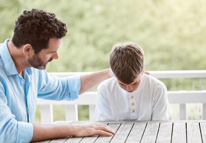Man comforting upset boy on porch, capturing emotion in real-life stories of people becoming what they once hated.
