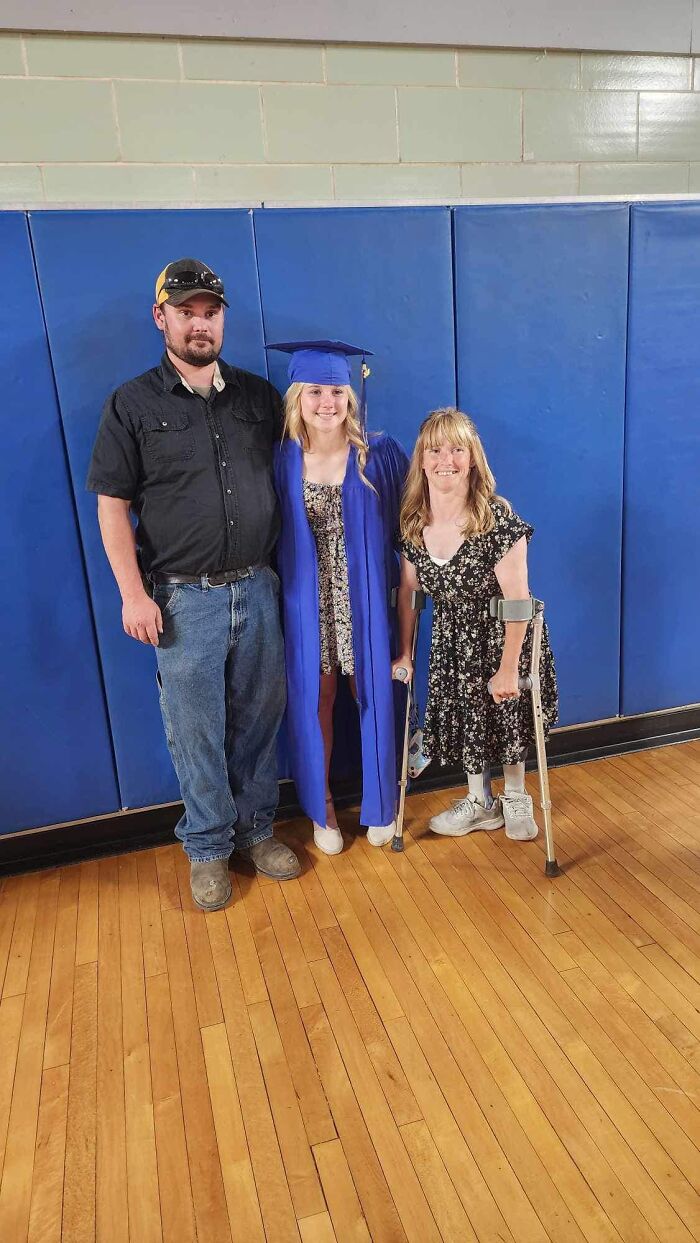 Family posing in a gym with a teenage girl in graduation attire, highlighting a soul-crushing accidental tragedy involving a dad. Family posing in a gym with a teenage girl in graduation attire, highlighting a soul-crushing accidental tragedy involving a dad.