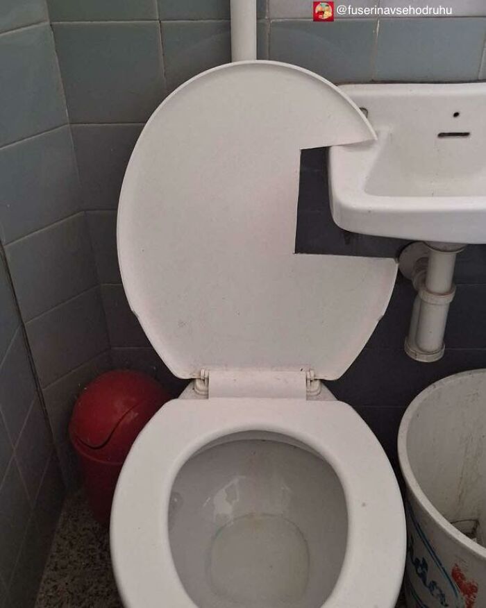 Toilet seat cut out to fit around a small sink, an unusual construction and design with poor practicality in a tight bathroom space