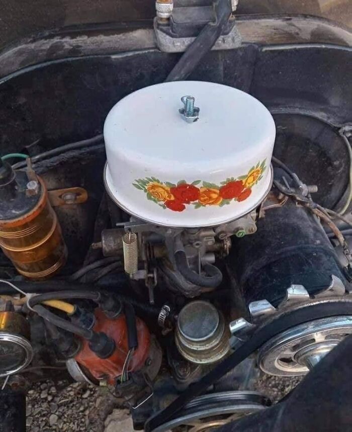Old car engine with a decorative floral tin cover, a quirky detail people raised in Eastern Europe can truly comprehend.