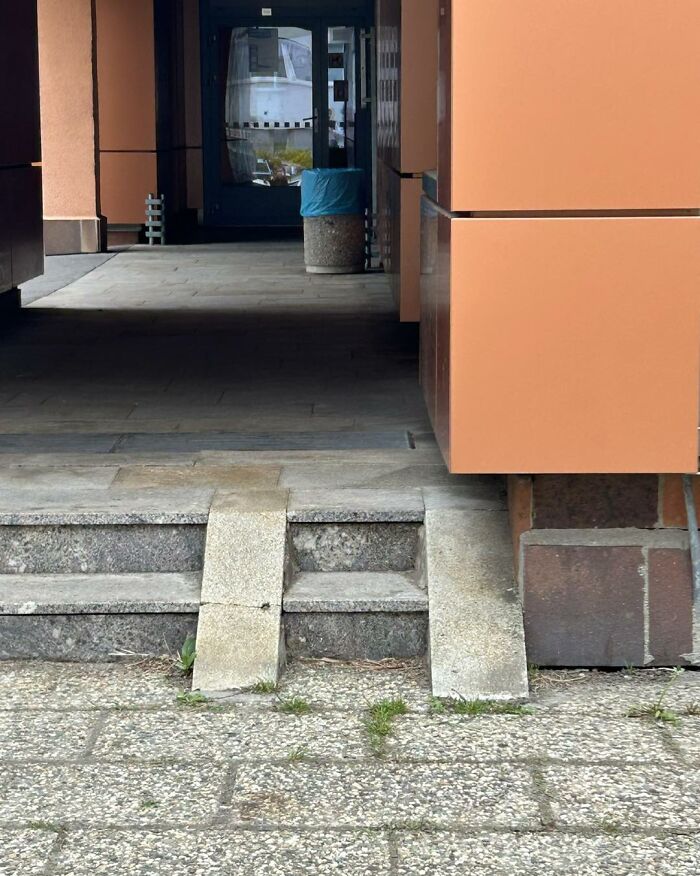 Ramp and stairs construction with poor design, showing uneven and impractical accessibility features in an outdoor building area.