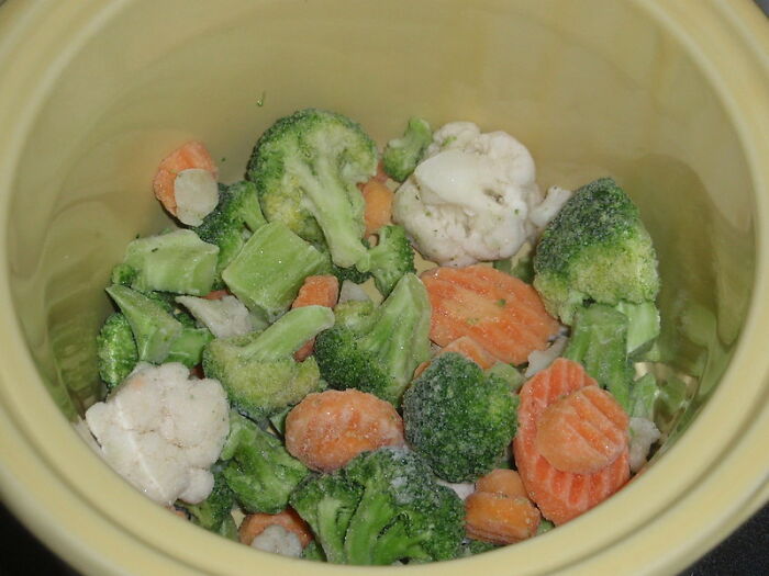 Frozen mixed vegetables in a bowl, illustrating practical money-saving tips for budget-friendly meal preparation.