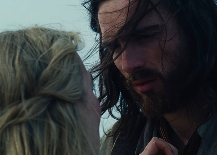 Close-up of Margot Robbie and Jacob Elordi in a moody scene from Wuthering Heights teaser evoking 1800s period drama.