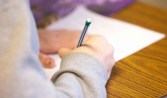 Person writing on a sheet of paper with a pencil, illustrating creative loopholes people exploited to save money.
