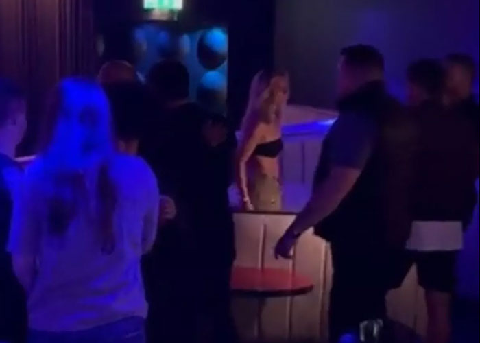 Crowd gathered in dimly lit nightclub with adult star Bonnie Blue involved in a chaotic event escalating quickly. Crowd gathered in dimly lit nightclub with adult star Bonnie Blue involved in a chaotic event escalating quickly.
